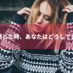 階段に座っている白と黒のセーターを着ている女性