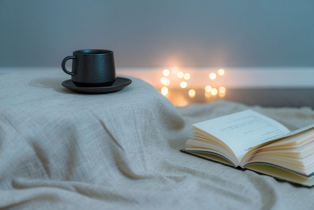 薄暗い部屋に黒いコーヒーカップと開いた本