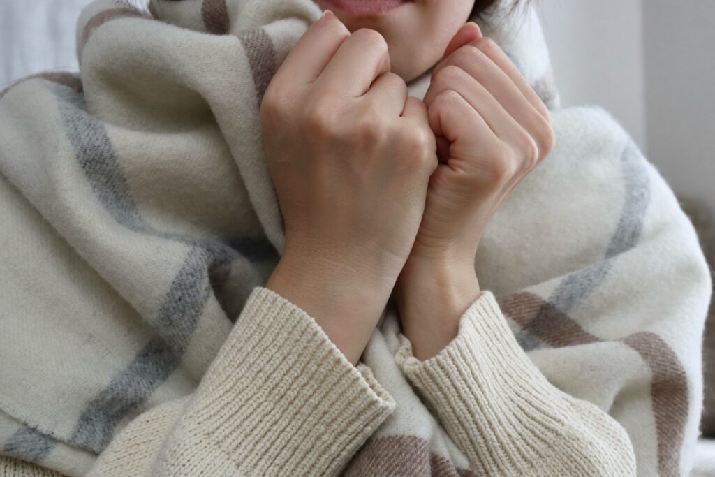 マフラーを巻いた寒そうな女性